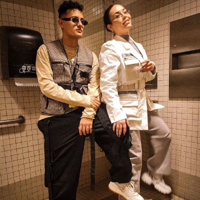 Both Jesaaelys Ayala González and Carlos Olmo is sitting on a chair as both of them are wearing shades and white sneakers.